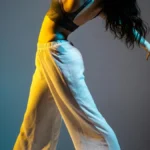 A dancer performing under dramatic stage lights, evoking ballroom and vogue performance