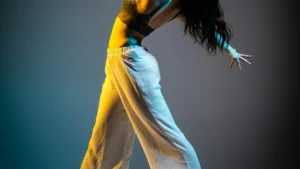 A dancer performing under dramatic stage lights, evoking ballroom and vogue performance