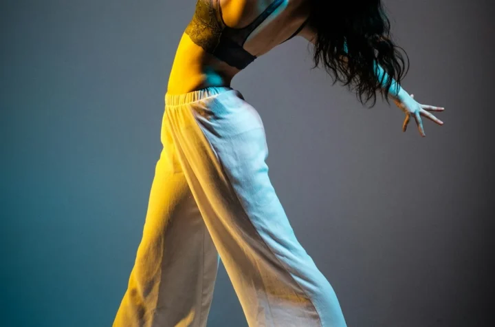 A dancer performing under dramatic stage lights, evoking ballroom and vogue performance